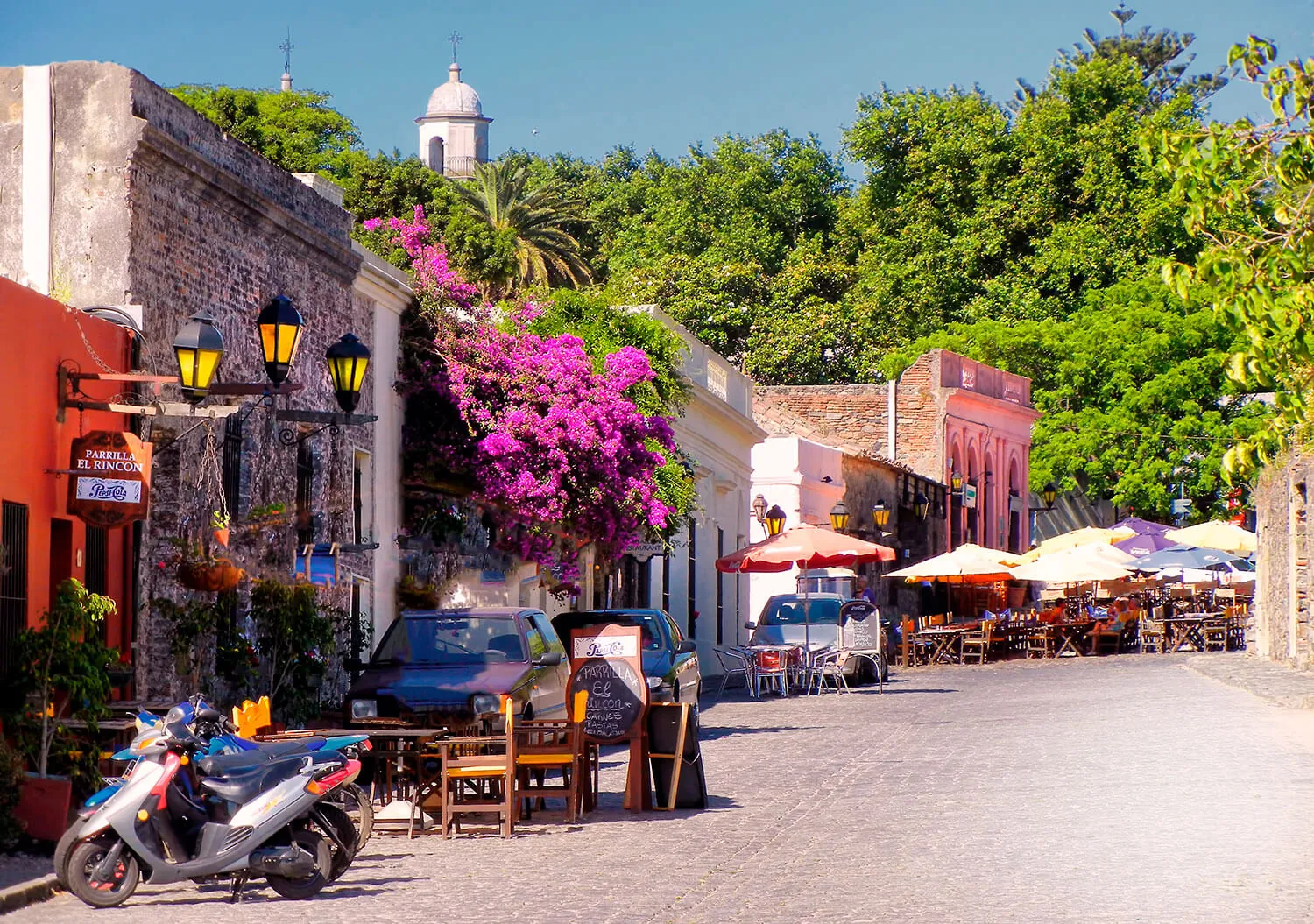 Cobblestone street in Colonia del Sacramento lined with colonial façades and bougainvillea